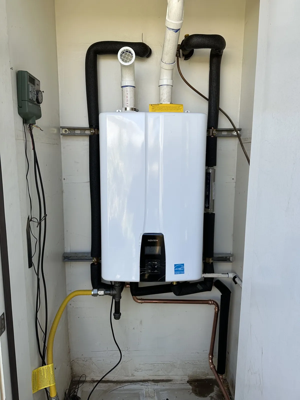 Tankless water heater installed in an outdoor enclosure