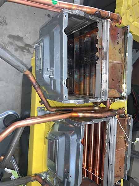 Tankless water heater heat exchangers opened for repair and descaling